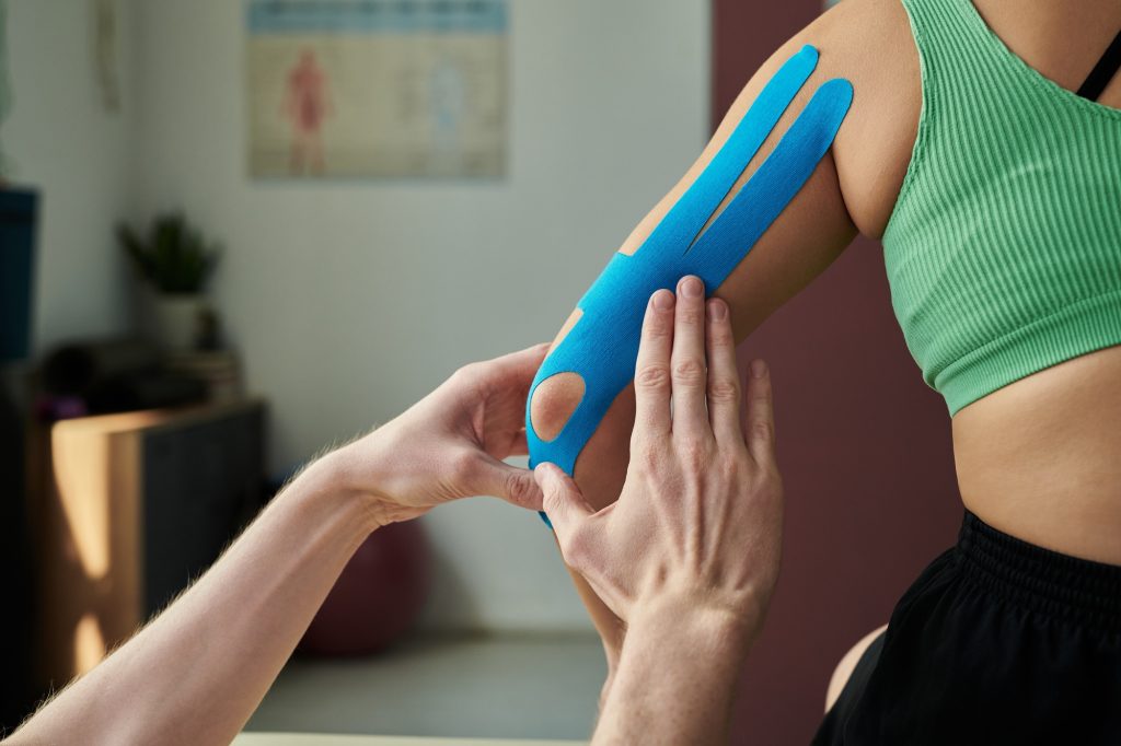 Applying Physiotherapy Tape On Arm For Muscle Support