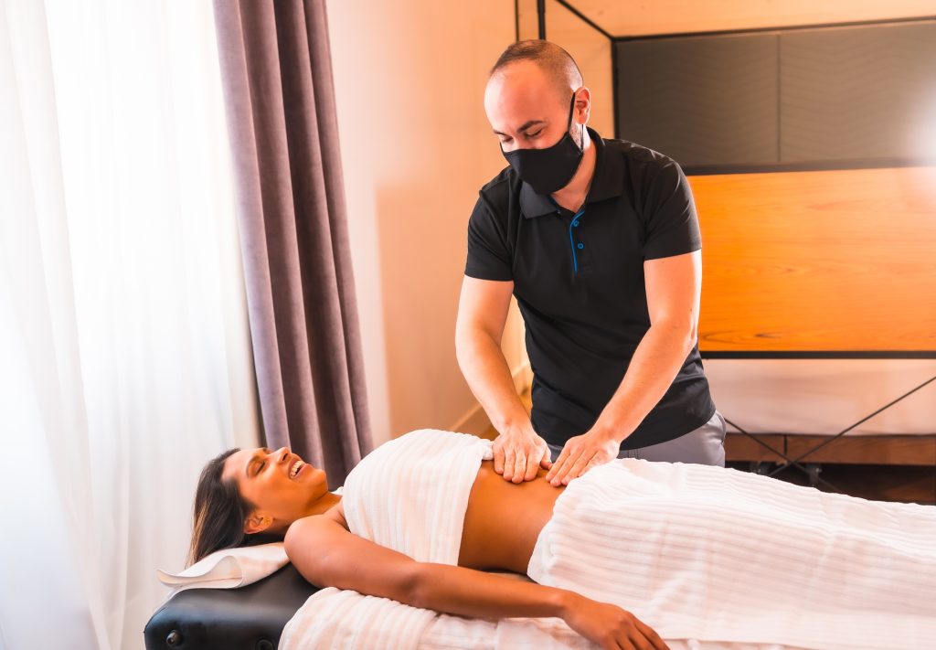 Home massage, a young man performing a massage at the client's home